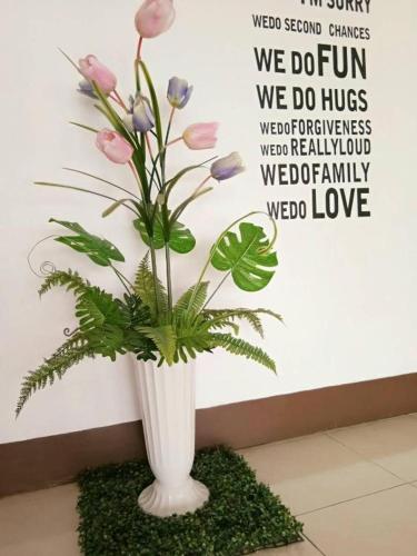 a white vase with a plant in it at Rueangrat Hotel in Ranong