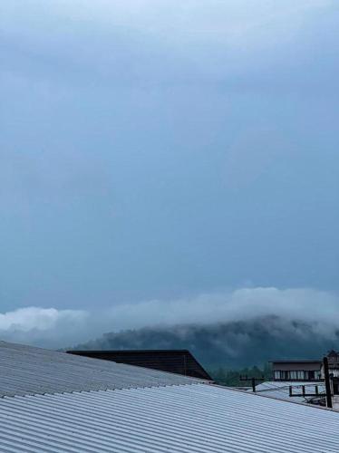 a snow covered roof of a house with clouds in the background at Rueangrat Hotel in Ranong