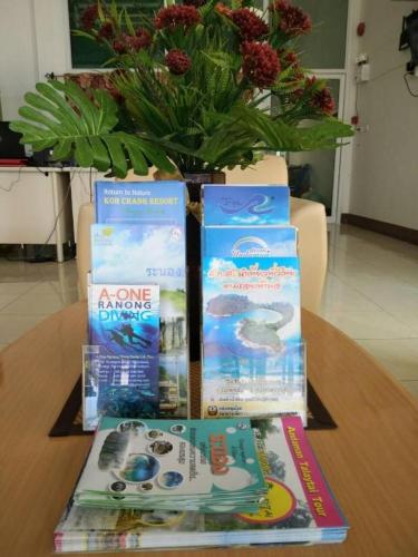 three books on a table with a vase at Rueangrat Hotel in Ranong