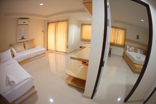 a living room with two beds and a table at Baan Sanpoom in Phitsanulok