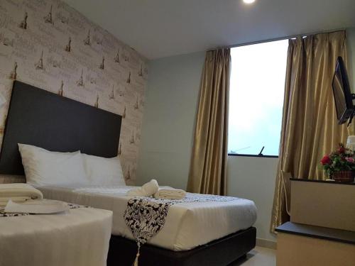 a hotel room with two beds and a window at City View Hotel At KLIA & KLIA2 in Kuala Lumpur