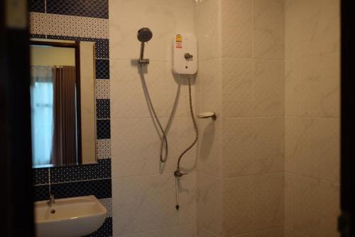 a shower in a bathroom with a phone on the wall at JITRA RESORT in Sukhothai