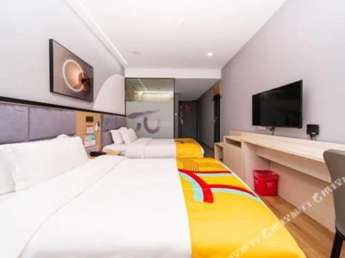 a hotel room with a large bed and a tv at Pai Hotel Xi'an Electronic Zheng Street in Xi'an