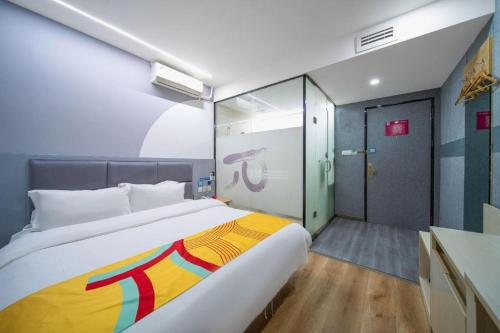 a bedroom with a large bed and a sliding glass door at Pai Hotel Xi'an Electronic Zheng Street in Xi'an