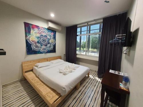 a bedroom with a bed and a painting on the wall at De Chukai Hotel in Cukai