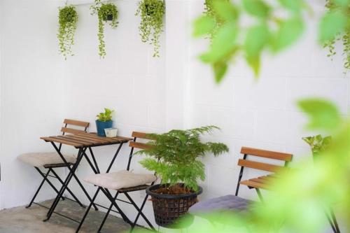 a patio with chairs and a table with plants at Silom Studios in Bangkok