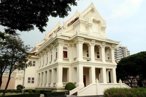 a white building with a tower on top of it at Silom Studios in Bangkok