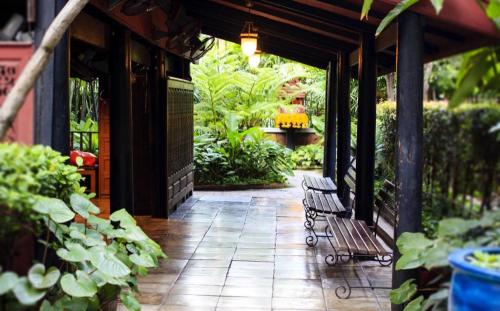 a patio with two benches on a building with plants at Silom Studios in Bangkok