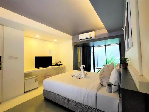 a bedroom with a large bed and a television at Silom Studios in Bangkok