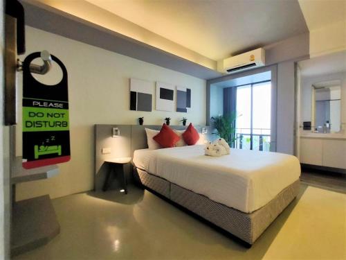 a bedroom with a bed with a do not disturb sign at Silom Studios in Bangkok