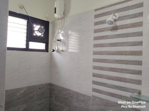a bathroom with a shower with a striped wall at Annamaiah Premium & Grand - 2 & 3 BHK Apartments for Families - Homestay & Home Food Service in Tirupati
