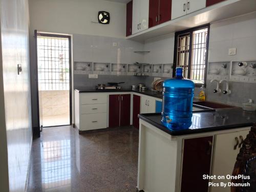 a large kitchen with a blue water bottle on the counter at Annamaiah Premium & Grand - 2 & 3 BHK Apartments for Families - Homestay & Home Food Service in Tirupati