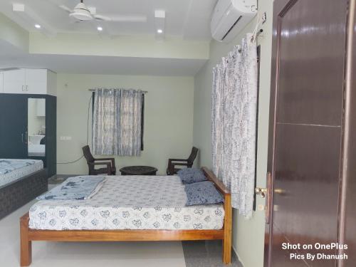 a bedroom with a bed and a window and a door at Annamaiah Premium & Grand - 2 & 3 BHK Apartments for Families - Homestay & Home Food Service in Tirupati