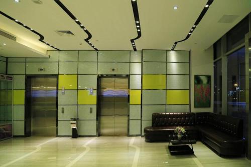 a lobby with a leather couch in a building at Lavande Hotels Suzhou Railway Station in Suzhou