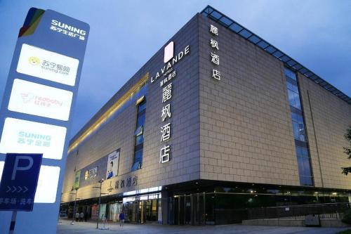 a large building with a sign in front of it at Lavande Hotels Suzhou Railway Station in Suzhou