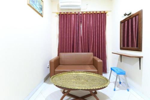a living room with a couch and a table and a chair at Andrin Daspatt Family Inn in Makassar