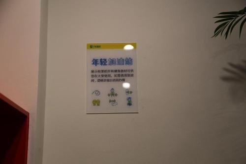 a sign on a white wall with writing on it at 7 Days Inn·Taixing Wenchang Road in Taixing