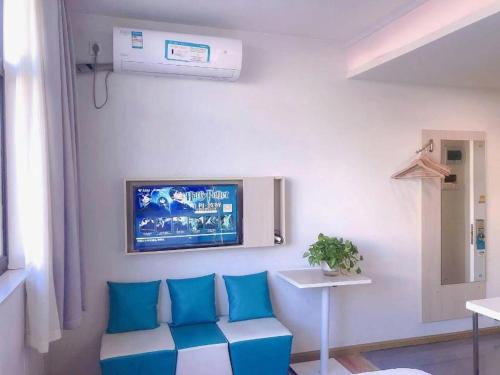 a living room with a couch and a tv on the wall at 7 Days Inn·Taixing Wenchang Road in Taixing