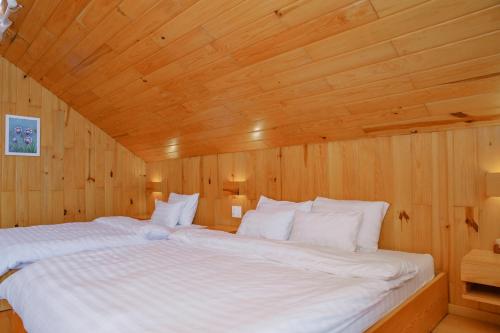 a bedroom with a large white bed with a wooden ceiling at La Maison Dalat in Ấp Man Ling
