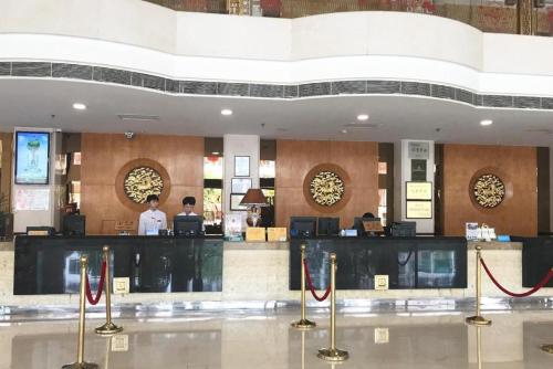 a lobby of a hotel with a bar and two people at Chaozhou Hotel in Chaozhou