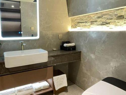 a bathroom with a white sink and a mirror at Chaozhou Hotel in Chaozhou