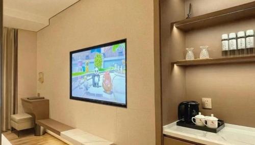 a room with a flat screen tv on a wall at Chaozhou Hotel in Chaozhou