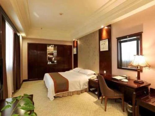 a hotel room with a bed and a desk at Chaozhou Hotel in Chaozhou
