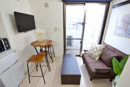 a living room with a couch and a table at Isole le Olena 4F in Naha