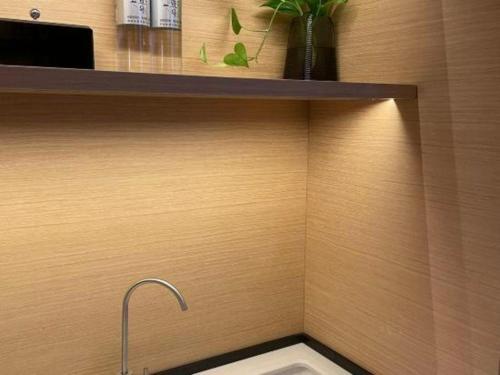 a bathroom with a sink and a shelf with a faucet at Chaozhou Hotel in Chaozhou