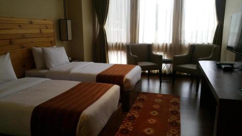 a hotel room with two beds and a table and chairs at The Pema by Realm in Thimphu