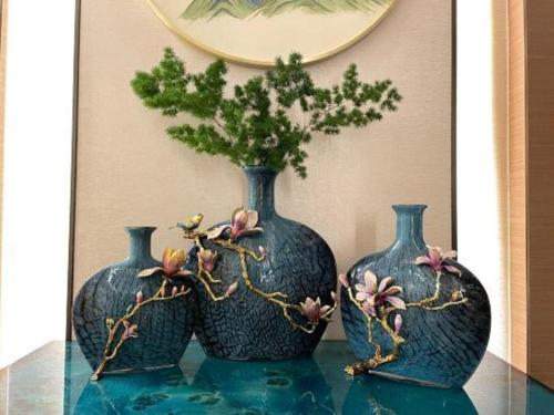 two blue vases sitting on a table with a plant in them at Chaozhou Hotel in Chaozhou