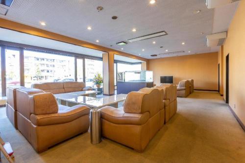 a conference room with a table and leather chairs at Tabist Hotel New Osamura Sabae in Fukui