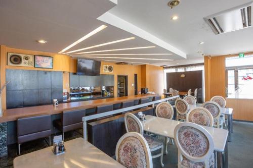 a restaurant with tables and chairs and a bar at Tabist Hotel New Osamura Sabae in Fukui