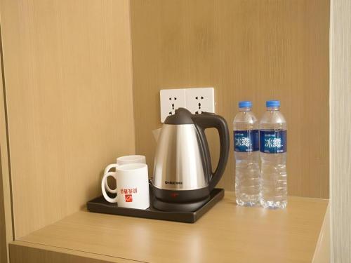 a coffee maker and two bottles of water on a shelf at Shell Changzhou Yangrong City Hotel in Changzhou