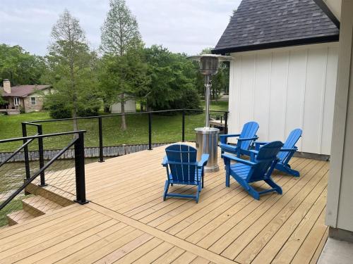 a deck with four blue chairs on it at Coffee Cove on Cedar Creek in Malakoff