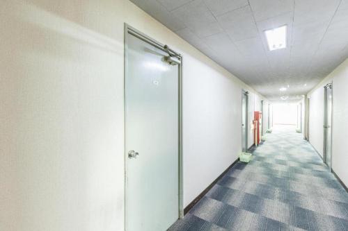 an empty hallway of an office building with a glass door at Tabist Joetsu Central Hotel Takada Nakamachi in Joetsu
