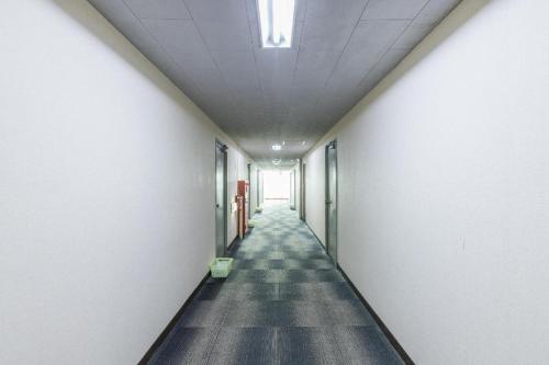 a hallway of an office building with a long corridor at Tabist Joetsu Central Hotel Takada Nakamachi in Joetsu