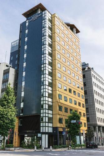 a tall building in the middle of a city at Hotel Yaenomidori Tokyo in Tokyo