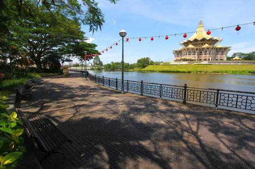 a park with a river and a building in the background at OYO 89465 Golden Lounge in Kuching