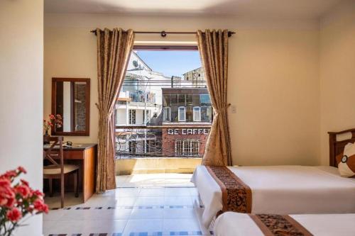 a hotel room with two beds and a window at Hung Phong Hotel - Near Dalat Night Market in Da Lat
