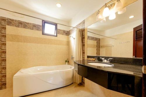 a bathroom with a tub and a sink and a bath tub at Hung Phong Hotel - Near Dalat Night Market in Da Lat