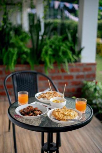 a table with plates of food and drinks on it at CoZy House Chiangrai in Chiang Rai