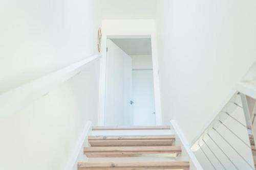a staircase in a house with white walls and wooden stairs at Relaxing Retreat in Terrigal in Terrigal