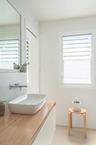 a white bathroom with a sink and a mirror at Relaxing Retreat in Terrigal in Terrigal