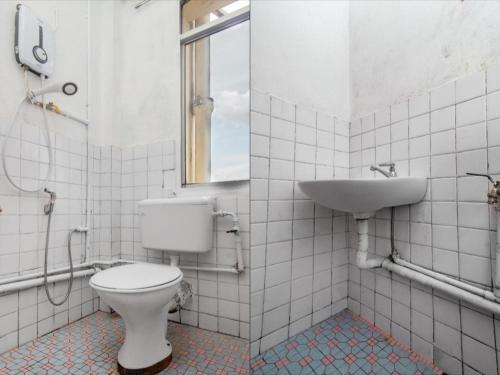 a bathroom with a toilet and a sink at OYO 89706 To-day Hotel in Sibu