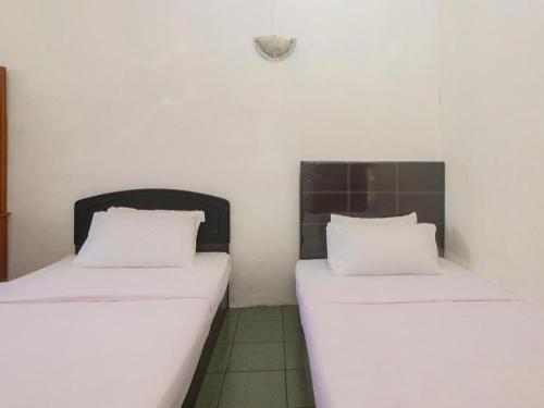 two beds sitting next to each other in a room at OYO 89706 To-day Hotel in Sibu