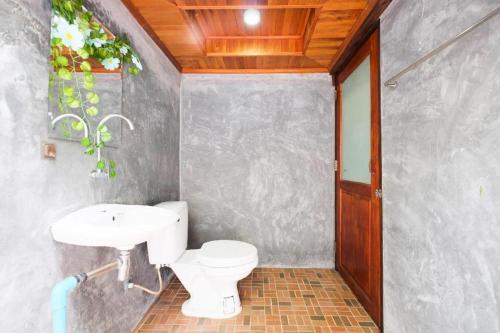 une salle de bain avec des toilettes blanches et un lavabo dans l'établissement OYO 604 Ruen Mai Horm Resort, à Ban Khok Khilek