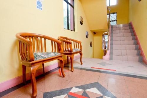 two wooden chairs in a room with a staircase at OYO 89958 Hotel Umimas in Lahad Datu