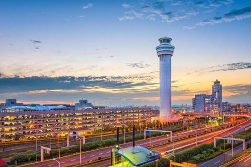 a city with a control tower and a freeway at KEIKYU EX INN Haneda Innovation City 2 minutes walk from HICity Exit of Tenkubashi Station in Tokyo