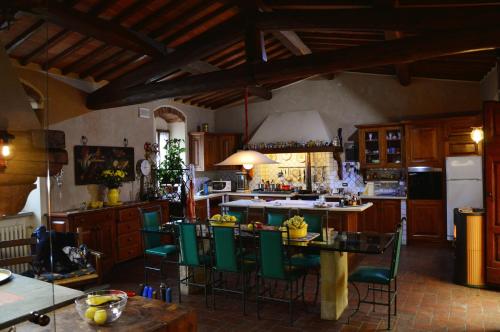 a kitchen with a table and green chairs at B&B Il Castello in Castiglion Fibocchi